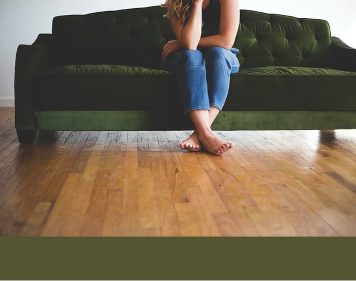 Woman Sat On Khaki Green Sofa