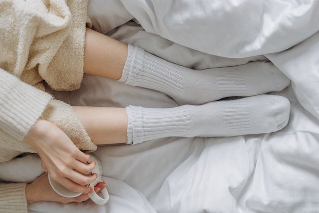 White socks and a mug in bed