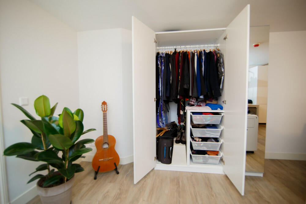 Bedroom With Open Wardrobe and Guitar